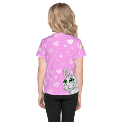 A girl wearing a pink shirt with white hearts and a bunny.