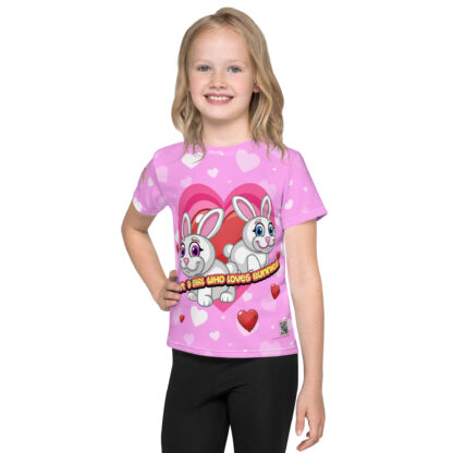 A girl wearing black pants and pink shirt with hearts.