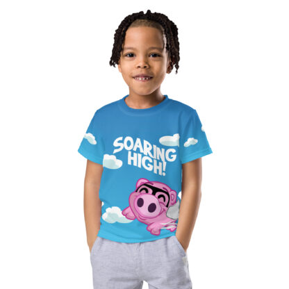 A kid wearing a t-shirt with the words " soaring high !" on it.