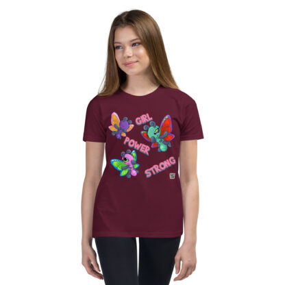 A girl wearing a maroon t-shirt with colorful butterflies.
